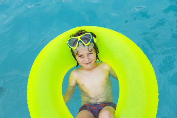 smiling 5 year old boy in colorful floatie